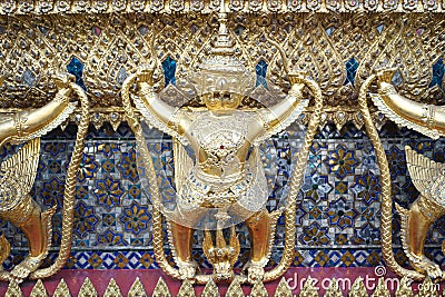 The golden beautiful ornamental of Thailand art & craft of Garuda holding the Naga at The Temple of the Emerald Buddha Editorial Stock Photo