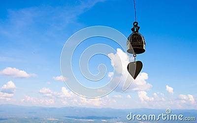 A golden bell hanging against the backdrop of beautiful sky Stock Photo