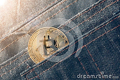 Golden bitcoin coin in jeans pocket. Editorial Stock Photo