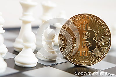 Golden bitcoin coin symbolizes elements with chess board Stock Photo