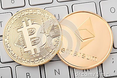 Golden bitcoin and ethereum coins on white keyboard, clipping path Editorial Stock Photo
