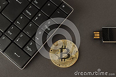 Golden bitcoin, keyboard and flash drive on a dark background top view Stock Photo