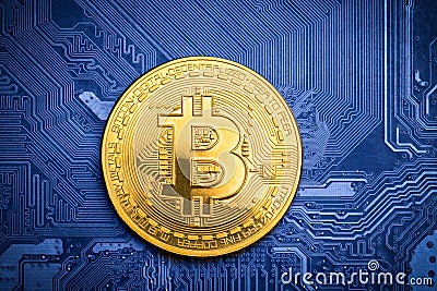 Golden bitcoin on printed circuit board Stock Photo