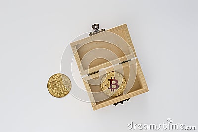 Golden bitcoin in wood box on a grey background. Stock Photo