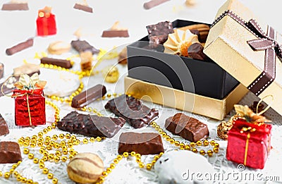 Golden box of chocolates, cookies and biscuits on festive table Stock Photo