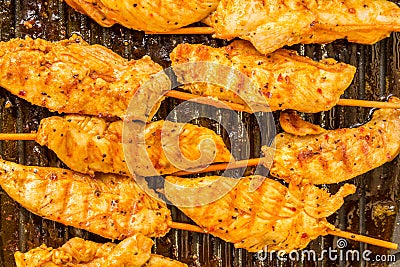 Golden brown chicken kababs grilling on pan Stock Photo