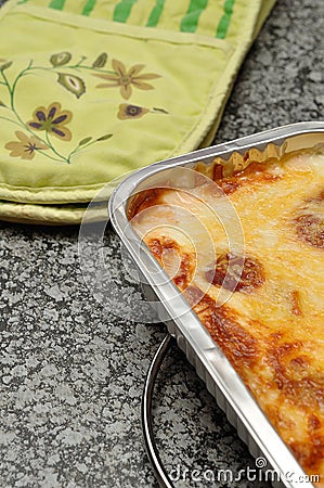 A golden brown lasagne displayed in a foil tin holder Stock Photo