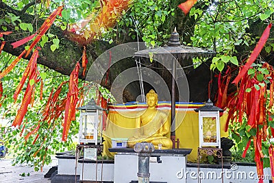 Golden Buddha sculpture with red Chinese talisman Stock Photo