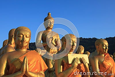 golden buddha statue in temple with beautiful morning light against blue sky use for multipurpose in religion theme Stock Photo