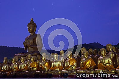 golden buddha statue in temple with beautiful with star tail against blue night sky Stock Photo