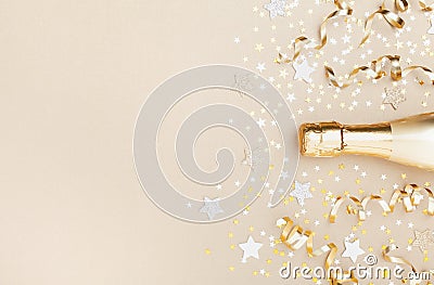 Golden champagne bottle with confetti stars and party streamers top view. Christmas, birthday or wedding background. Flat lay Stock Photo