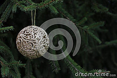 Golden Christmas ball on the fir tree. Close-up of beautiful luxury ornament Stock Photo