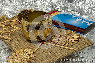 Golden Christmas decoratin with straw stars, candlesticks and matches Stock Photo