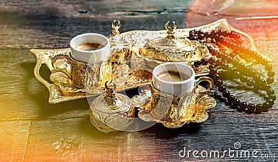 Golden coffee cups rosary beads wooden background light leaks Stock Photo