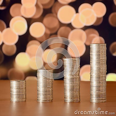 Golden coin stacks arranged as a graph. Increasing columns of coins Stock Photo