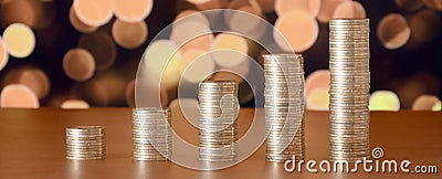 Golden coin stacks arranged as a graph. Increasing columns of coins Stock Photo