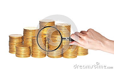 Golden coins and hand holding magnifying glass isolated Stock Photo