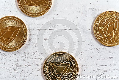 Golden commemorative EOS - EOSIO cryptocurrency - coins on white stone board, flat lay view Stock Photo