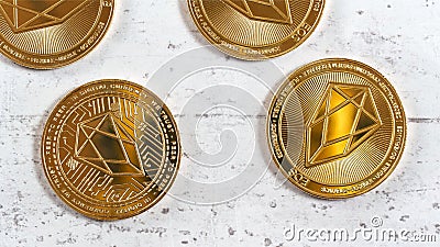 Golden commemorative EOS - EOSIO cryptocurrency - coins on white stone board, overhead photo Stock Photo
