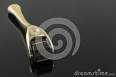 Golden derma roller for medical micro needling therapy. Stock Photo