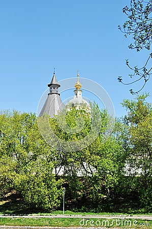 The golden dome of the bell tower and the gray roof of the monastery tower on a blue background Stock Photo