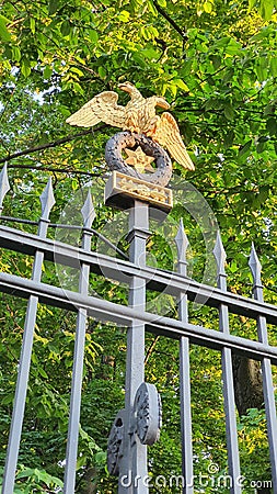 Golden double-headed eagle as a decorative element of a cast-iron fence post. Stock Photo