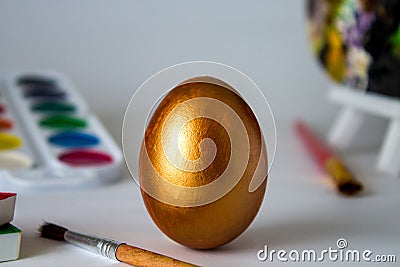 Golden Easter egg on a watercolor background. Simple holiday composition. Art work, handmade for decoration for Easter Stock Photo