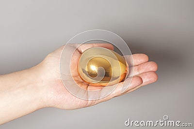 Golden egg in hand on gray Stock Photo