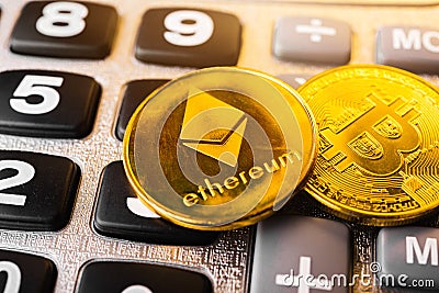 Golden ether coins or Ethereum network exchange on calculator Editorial Stock Photo