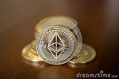 Golden Etherium coin close up. Ether is a cryptocurrency whose blockchain is generated by the Ethereum platform. Editorial Stock Photo