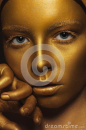 Golden Face. Woman with Luxury Gold Make-up. Stock Photo