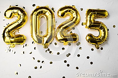 golden foil balloon number 2025. New Year two thousand twenty fifth and golden numbers. 20 and 25 on a gray concrete Stock Photo
