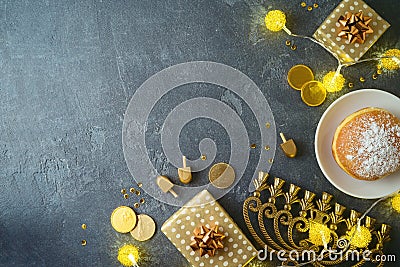 Golden gift box, traditional donuts and menorah on dark background. Hanukkah greeting card design Stock Photo