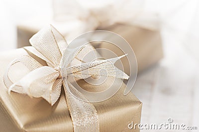 Golden gift boxes with beautiful ribbon and bow on a bright shiny background Stock Photo