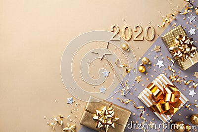 Golden gift or present boxes with golden bows, 2020 number and confetti top view. Christmas and New Year background. Flat lay Stock Photo