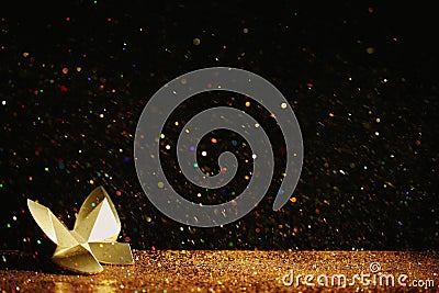 Golden glitter and decorative butterfly against black. Space for text Stock Photo