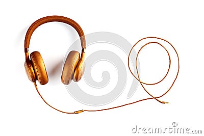 Golden headphones with a wire twisted into a spiral on a white background. View from above. Headphones for DJs Stock Photo