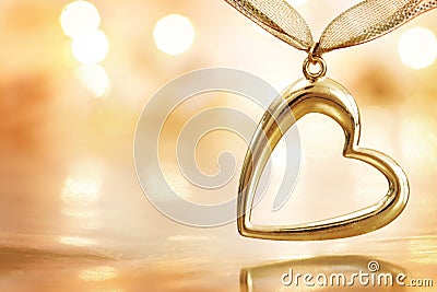 Golden heart on defocused lights background Stock Photo