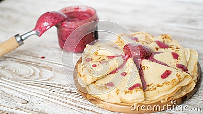 Golden homemade crepes served with blueberry cream in the jar on white wooden table. Nice breakfast for children Stock Photo