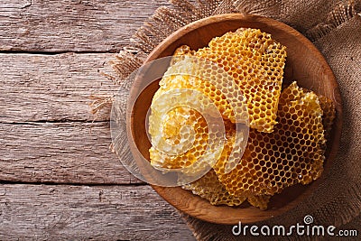 Golden honeycombs on a wooden plate. Horizontal top view Stock Photo