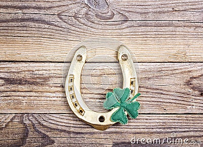 Golden horseshoe and clover leafon old wooden boards. St.Patrick Stock Photo