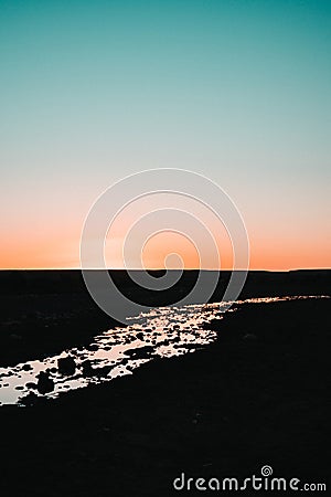 Golden hour river: A shimmering reflection of the setting sun transforms a river into a tranquil canvas of warm, golden hues, Stock Photo