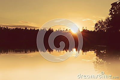 Golden hour sunset by a calm lake. Stock Photo