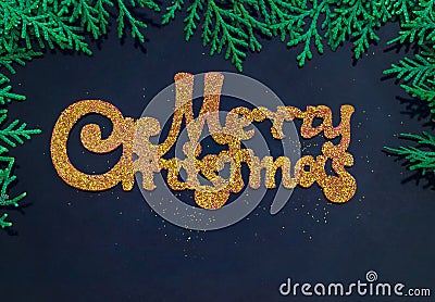 Golden inscription Merry Christmas on a blue background surrounded by branches of pine Stock Photo