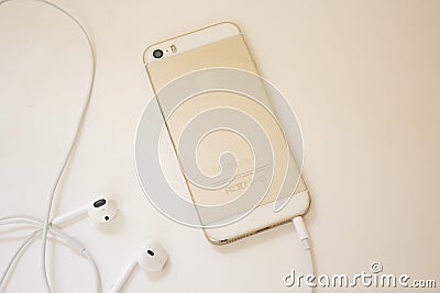 Golden iPhone 5s back and earphone wired - isolated Editorial Stock Photo