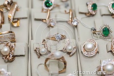 Golden jewellery with pearls and gemstones at showcase Stock Photo
