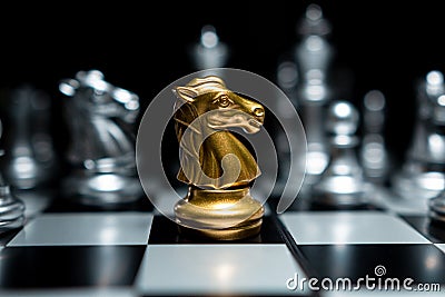 Golden knight chess surrounded by chess pieces Stock Photo