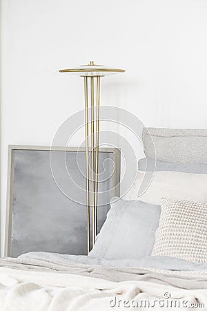 Golden lamp next to comfortable bed Stock Photo