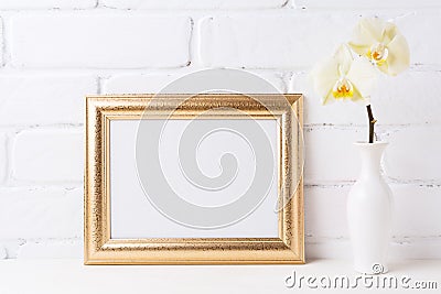 Golden landscape frame mockup with soft yellow orchid in vase Stock Photo