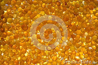 Close up of orange silica gel dessicant. Golden translucent beads with shiny light Stock Photo